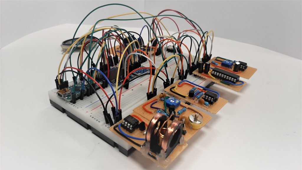 A prototype on an electrical breadboard. Many colorful wires are to be seen as well as individual modules on perfboards mounted to the main breadboard.
